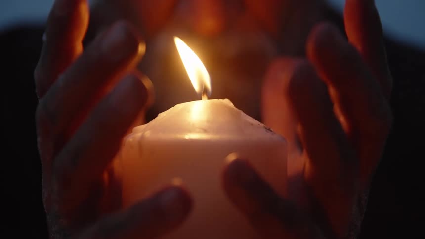 The man is holding a lit candle