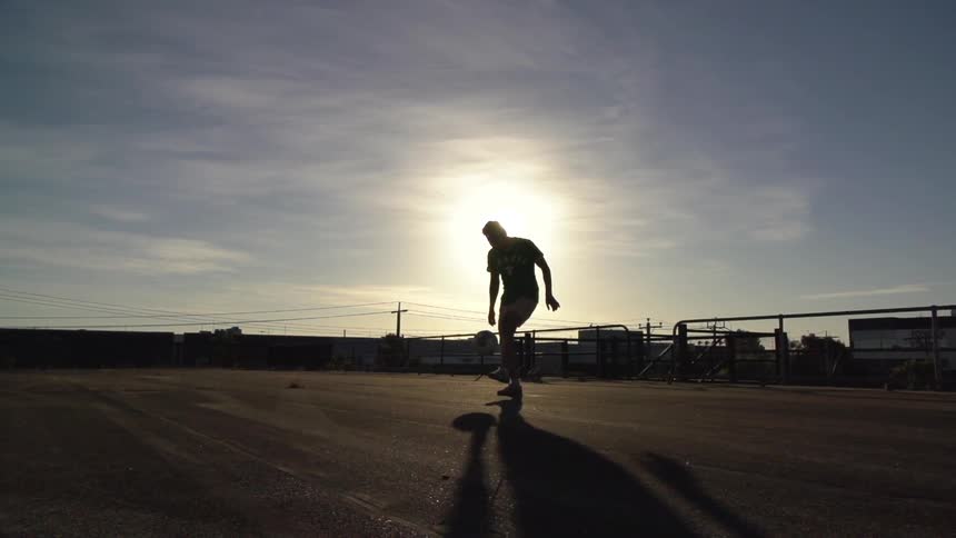 Man kicking a basketball into the air with his feet