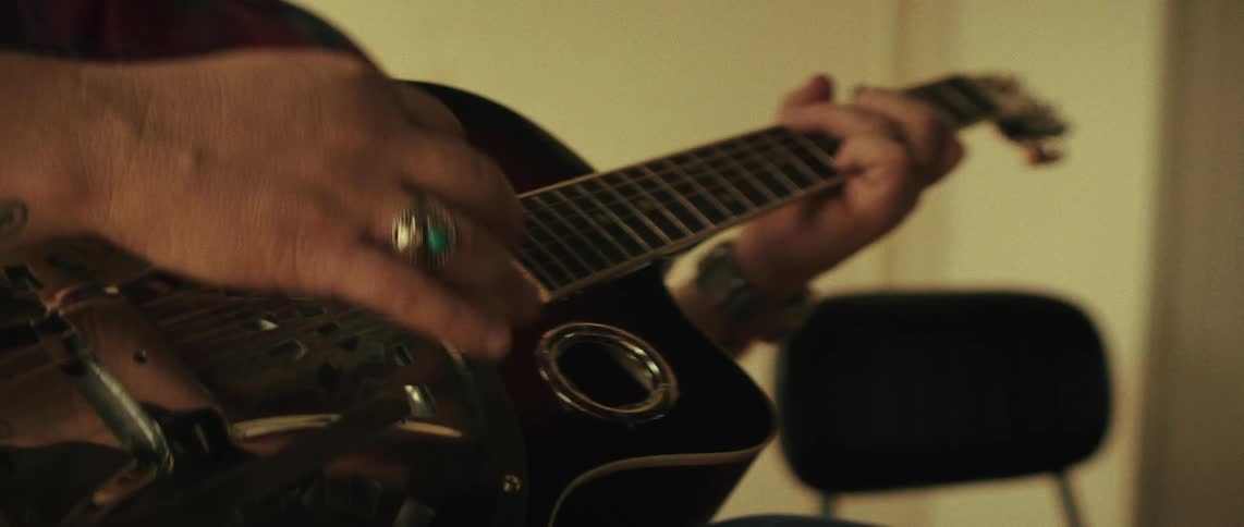 Musician moves his fingers on the strings and he plays his guitar