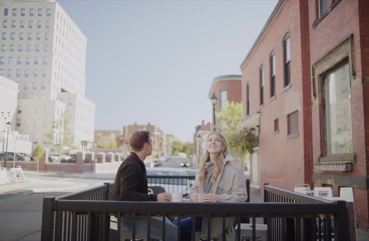 Couple sitting outdoors at a caf in a sunny city street