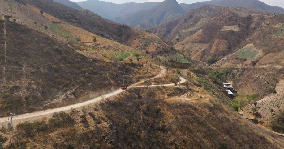 Vehicle takes a side road while traveling on a mountain road near farmland