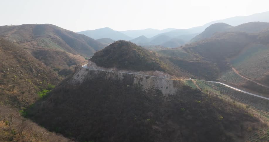 A road winds its way around and up a mountain