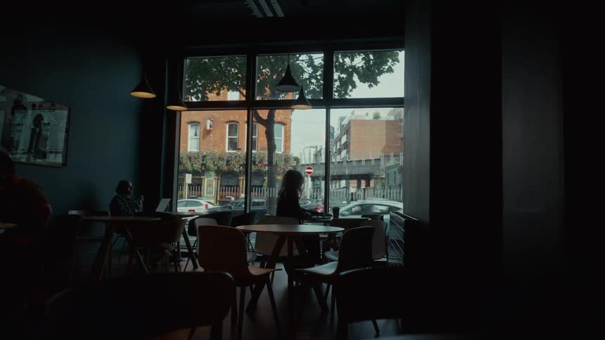 A woman sits down at a table in a coffee shop