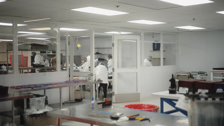 Coworkers work together in a lab with an open door