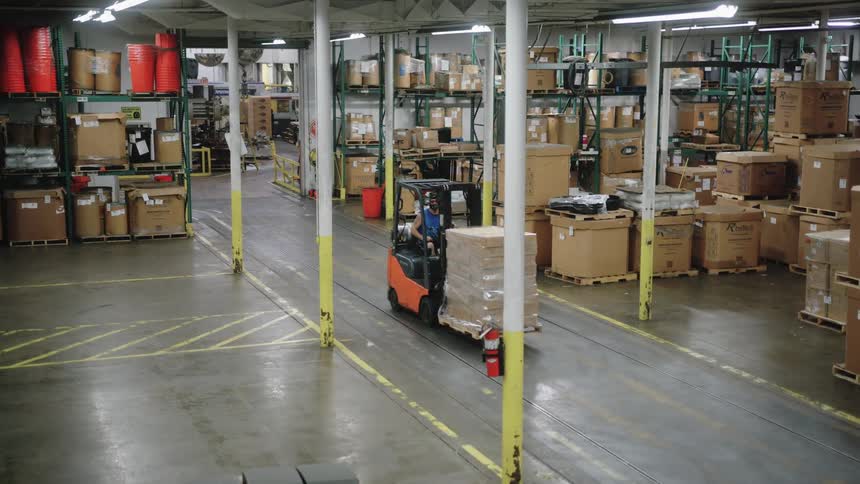 The forklift drives through the warehouse