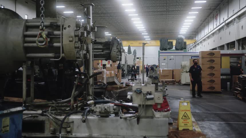 Male worker walks through a manufacturing plant