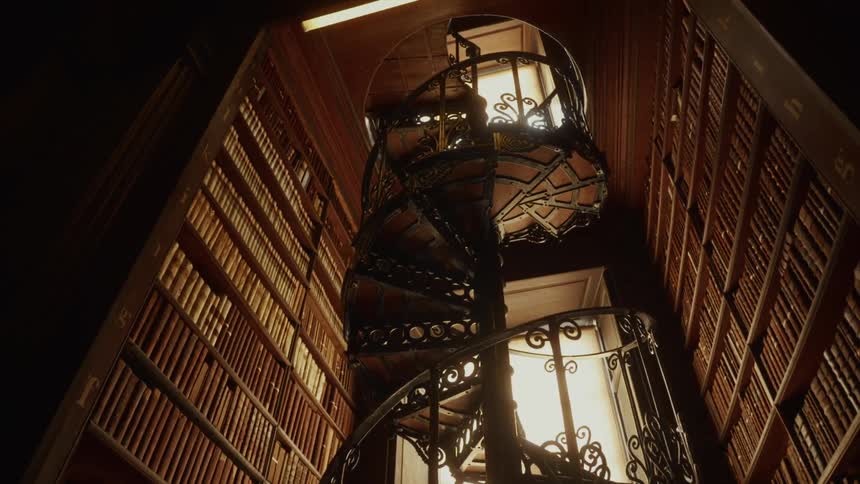 A spiral staircase in a room full of books