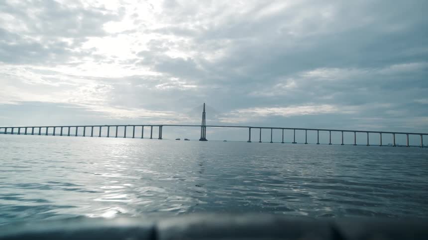 Boat heads toward a bridge on a cloudy day