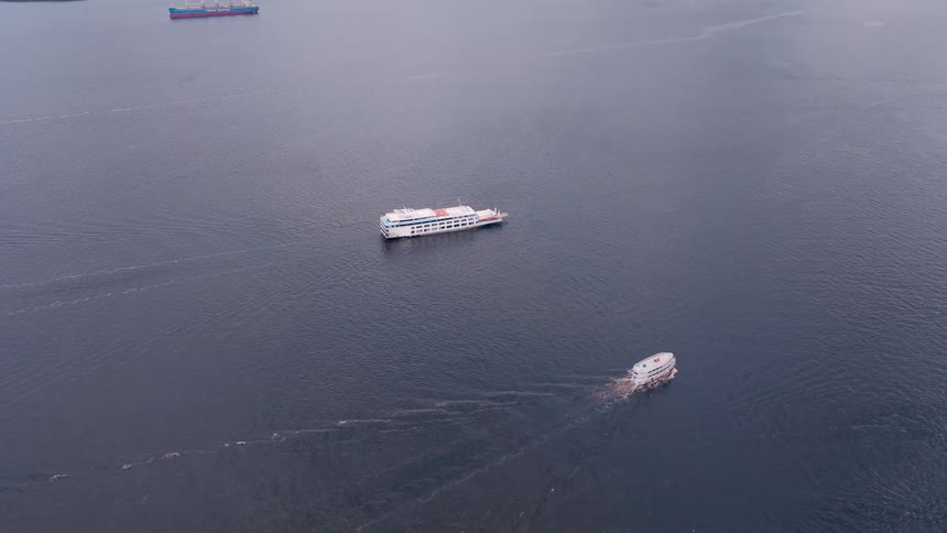 Aerial view of boats moving across a vast open sea