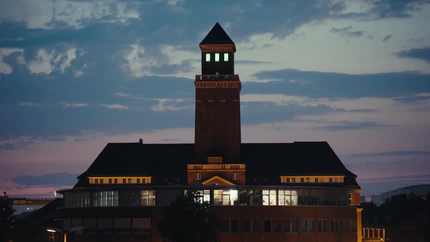 A large building silhouetted by the sunset