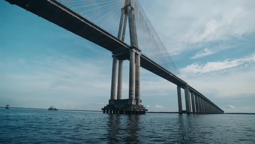 The large bridge goes over the shore line