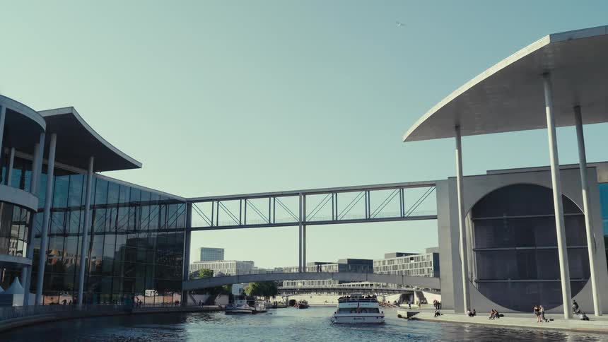 A boat glides along a city canal at midday