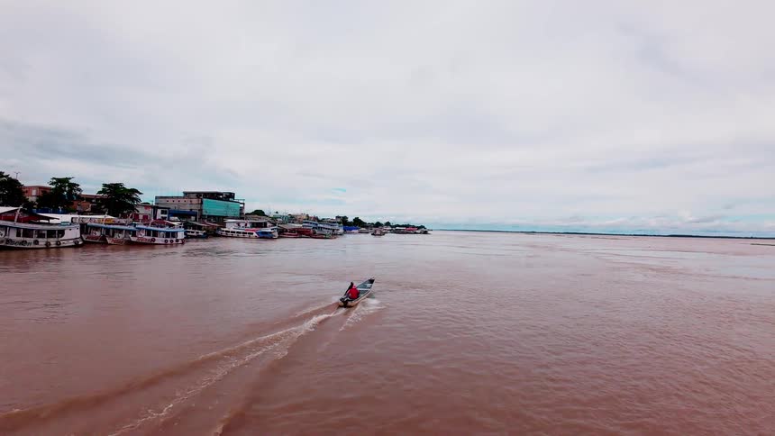 A boat holds 2 people as it moves through a body of water