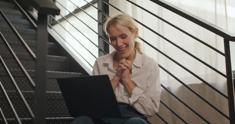 The woman talks with someone on her laptop
