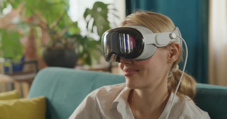 The woman sits down and puts on a virtual reality headset