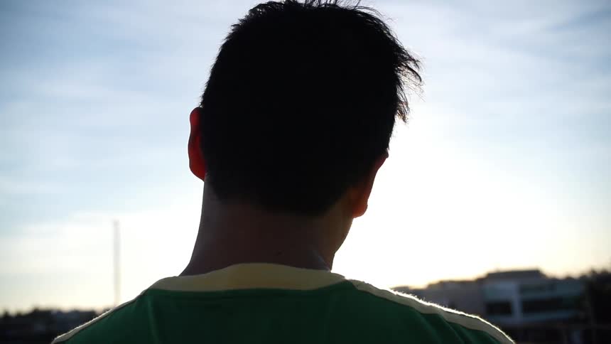 A man stares off into a cloudy sky