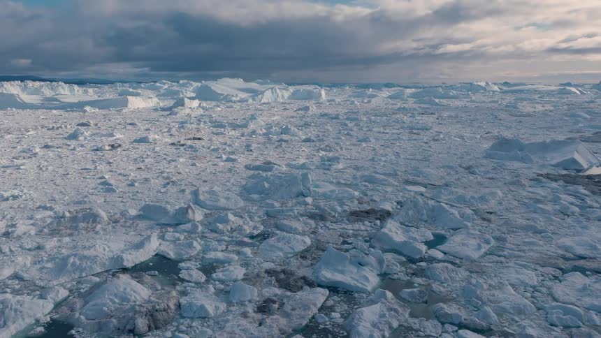 Melting broken ice and icebergs float on the arctic water