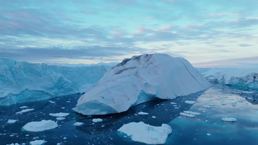 Aerial view of broken sea ice and jagged icebergs under cloudy sky