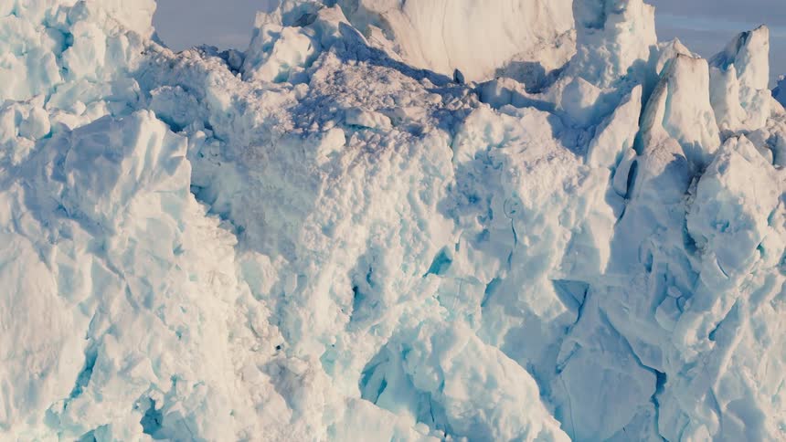 Aerial view of melting ice and snow mountains on an arctic glacier