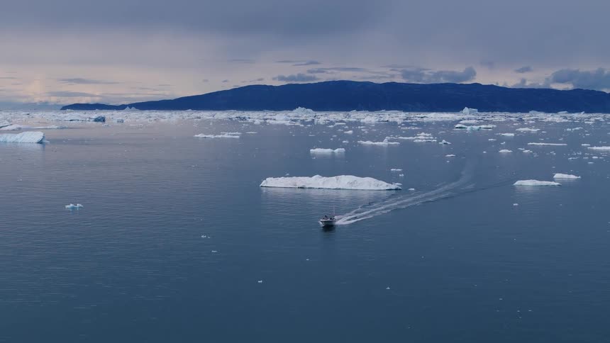 Aerial view of a speedboat moving through an icy glacier landscape
