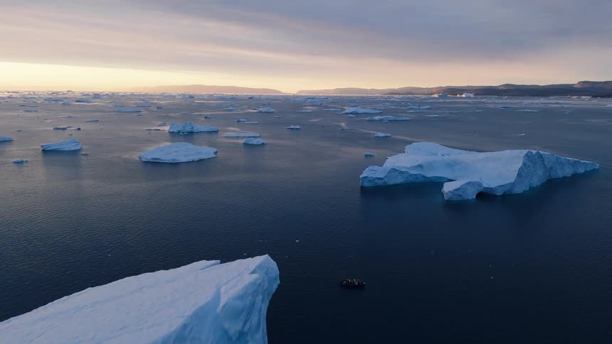 Melting icebergs and ice on the arctic water as a boat sails