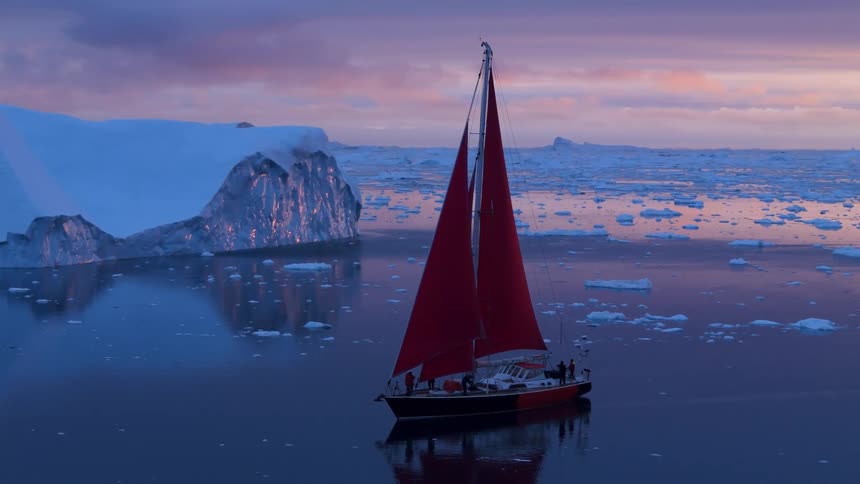 Crew on a ship sailing on arctic water among floating melting ice and icebergs