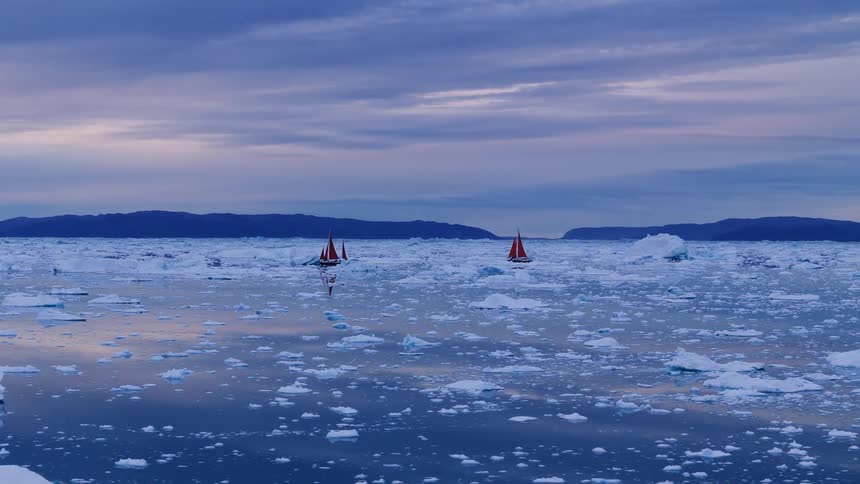 Boats sailing off the arctic coast among icebergs and floating ice