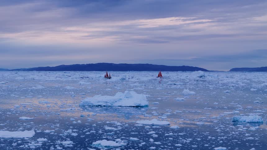 Boat sailing off the arctic coast among icebergs and floating ice