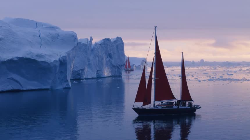 Boats sailing near glaciers and melting ice floating on the arctic water