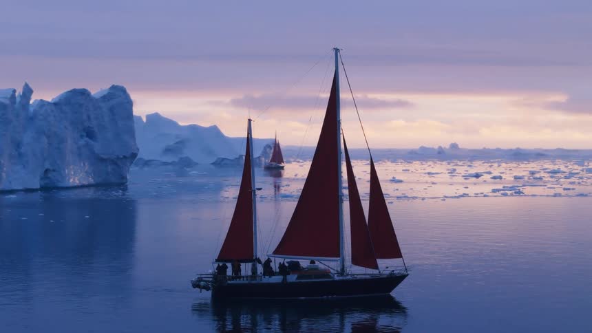 Crew on a ship sailing along the arctic coast among floating melting ice with another boat sailing in the distance