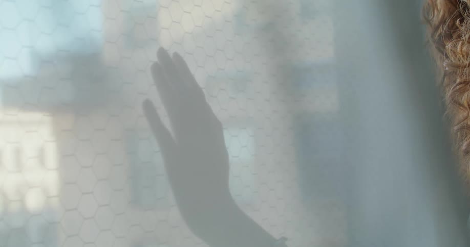 The video shows a closeup shot of a white honeycombpatterned material or screen a smooth reflective metallic object or cylinder slides across the surface partially obscuring it