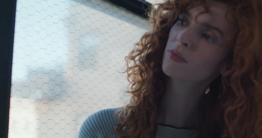 Pretty woman reading a book near a large window