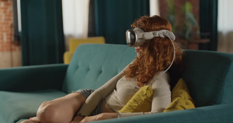 Woman explores virtual reality while sitting on a living room couch
