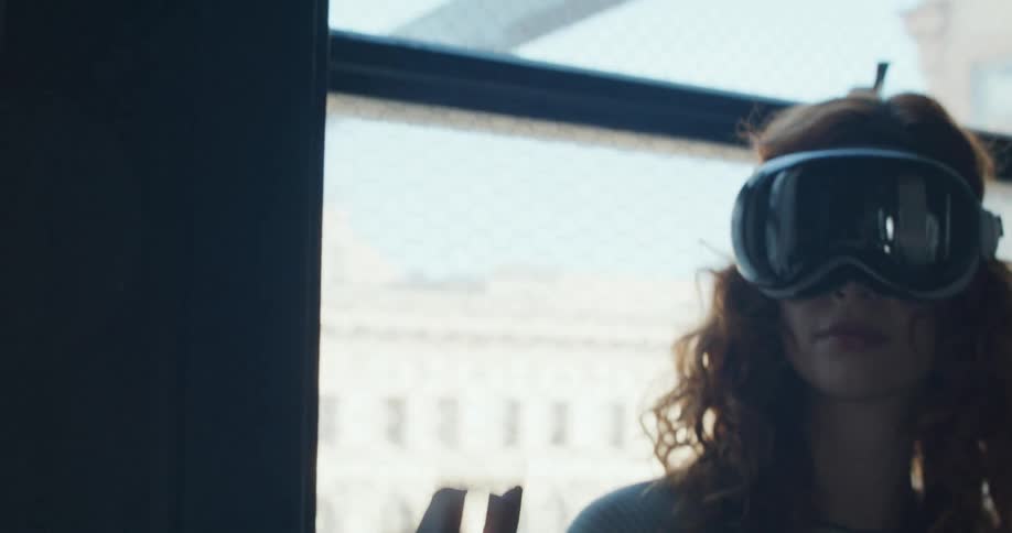 The woman pinches her finger and slides her hand while using a vr headset