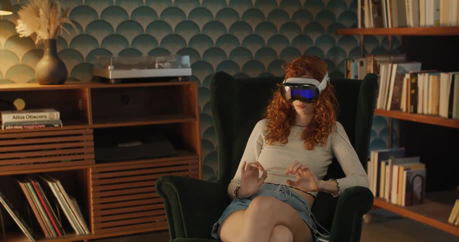 Woman sits on a chair using a vr headset in a living room