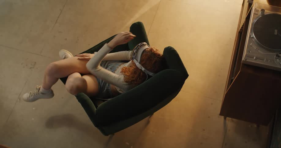 Redheaded female wears virtual reality goggles and interacts with virtual reality
