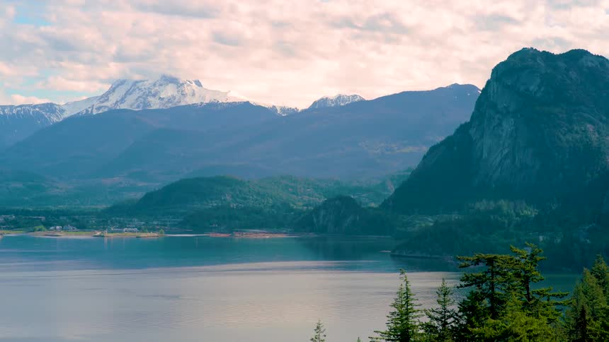 Aerial view of a town by a lake with snow capped mountains