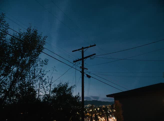 A tall powerline fills the sky at night