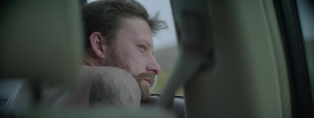 A man is looking out the window of a moving car