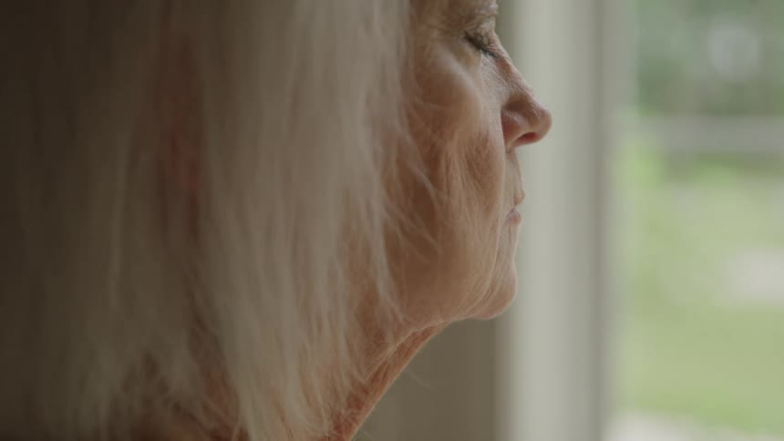 The woman looking out the window closes her eyes
