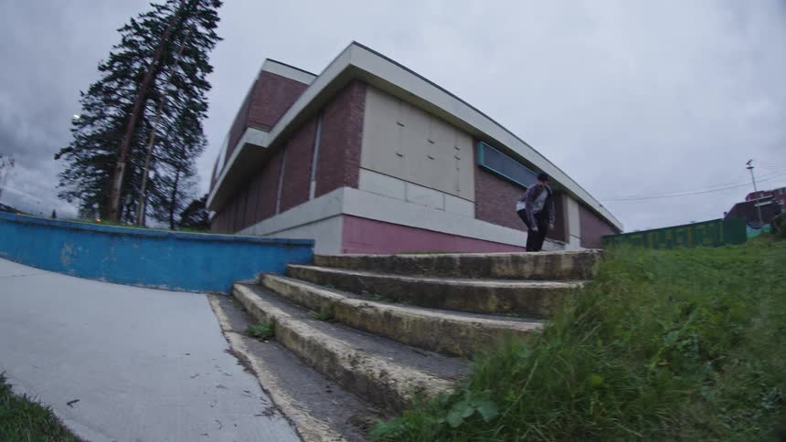 The man jumps down the steps on his skateboard