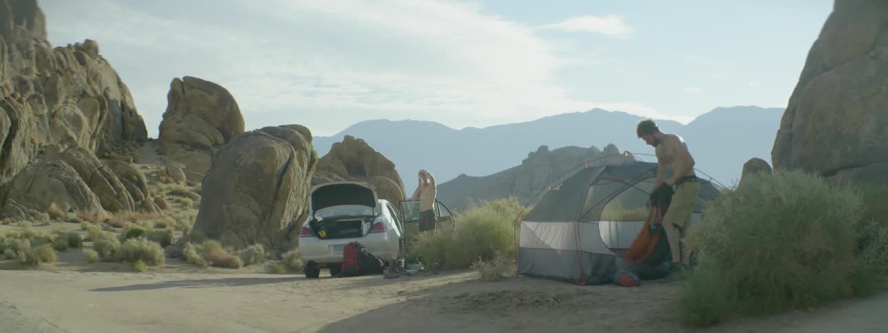 A man and woman are camping in the desert