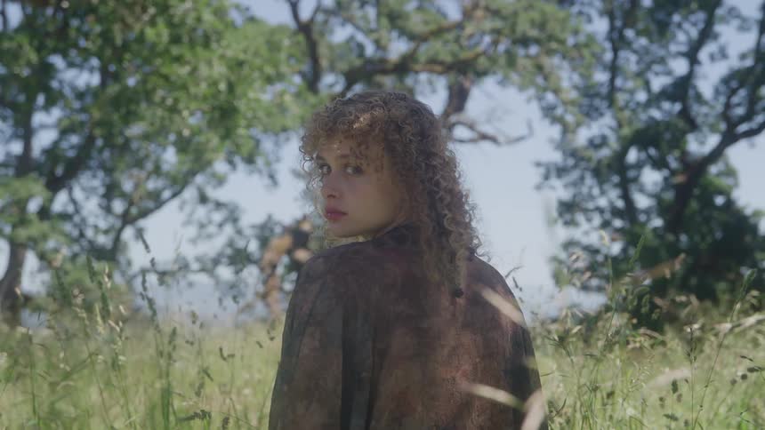 A woman turns to face the camera
