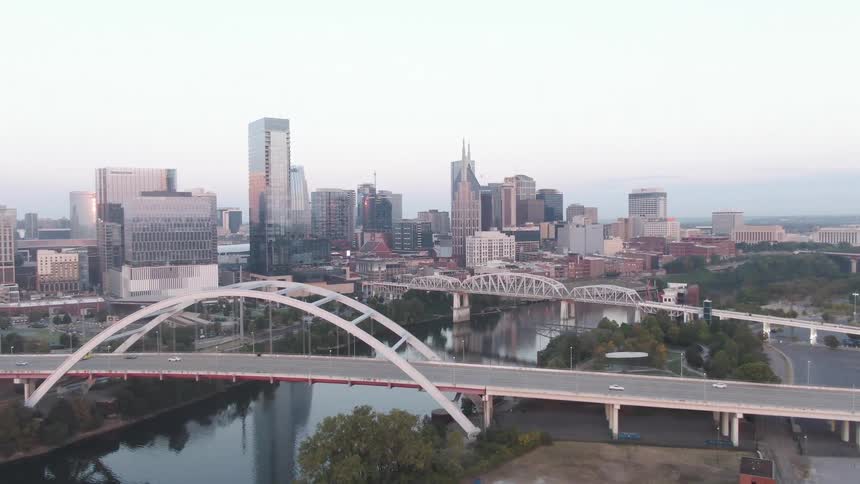An aerial view of two bridges passing over a large canal in the middle of a large city
