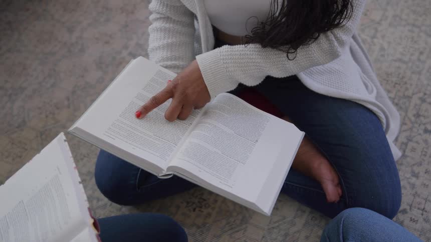 The woman is studying a text book