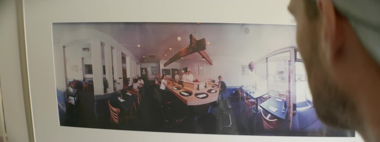 Two men looking at a photograph of a restaurant