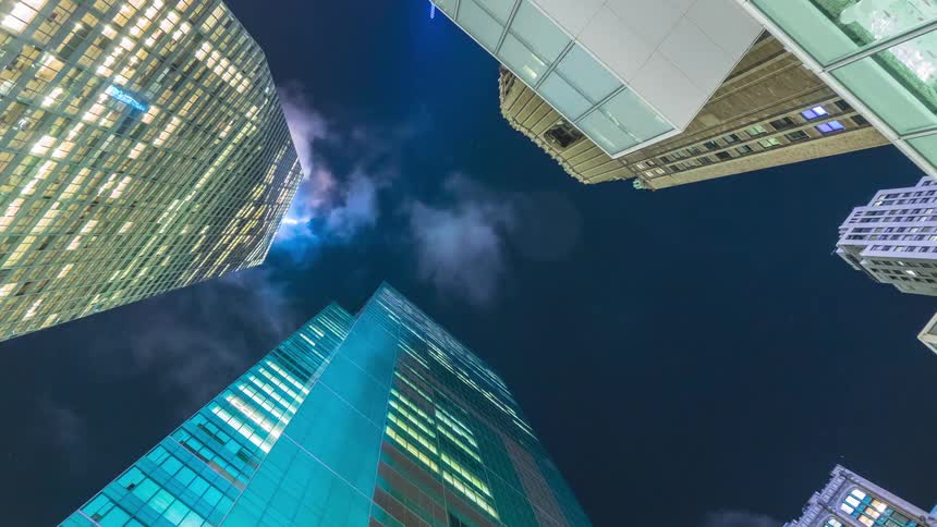 Colored light reflects on tall buildings and skyscrapers