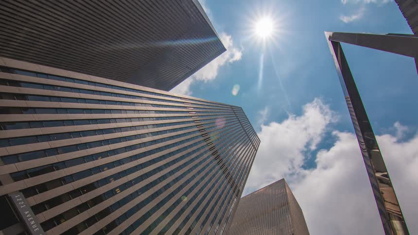 Clouds passing over downtown skyscrapers gather to conceal the sun