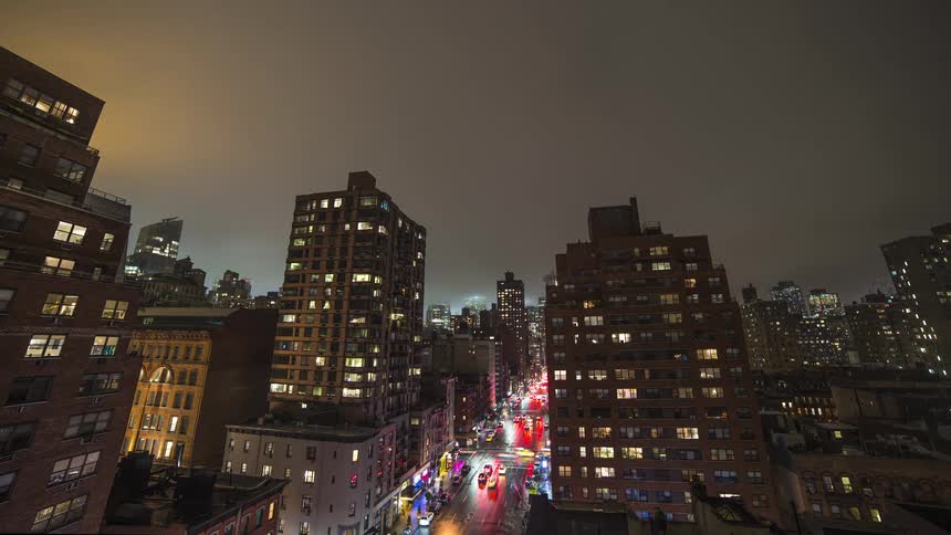 Lights on downtown buildings glow as traffic moves on the street