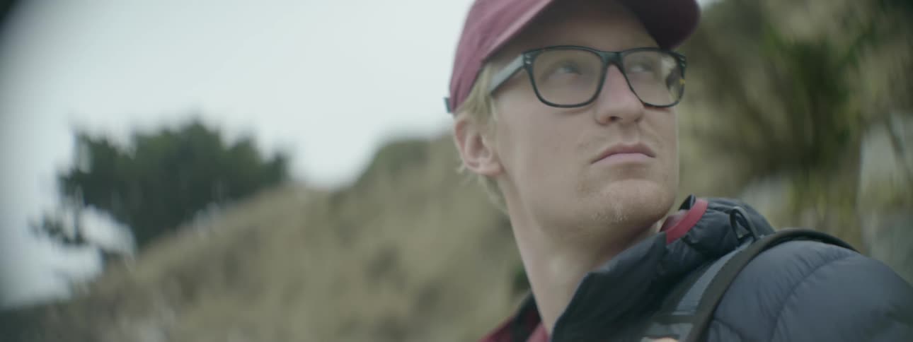 A man looks around wearing a cap